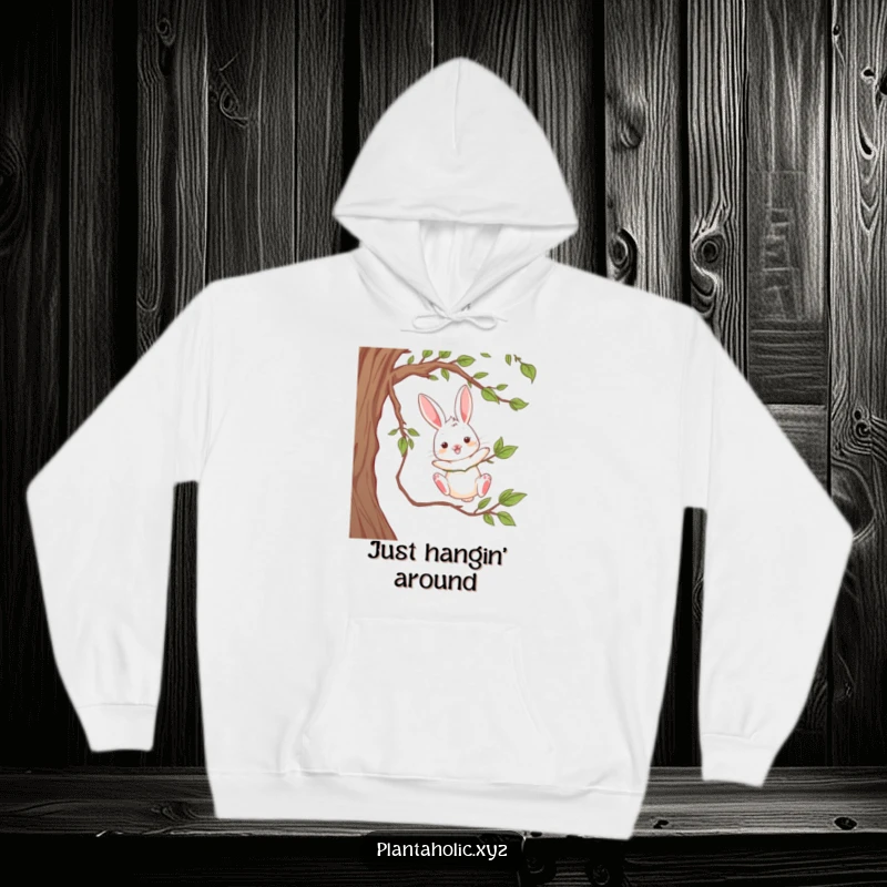 Funny hoodie with a playful rabbit dangling from a thick vine, mid-air, cozy and playful woodland apparel.